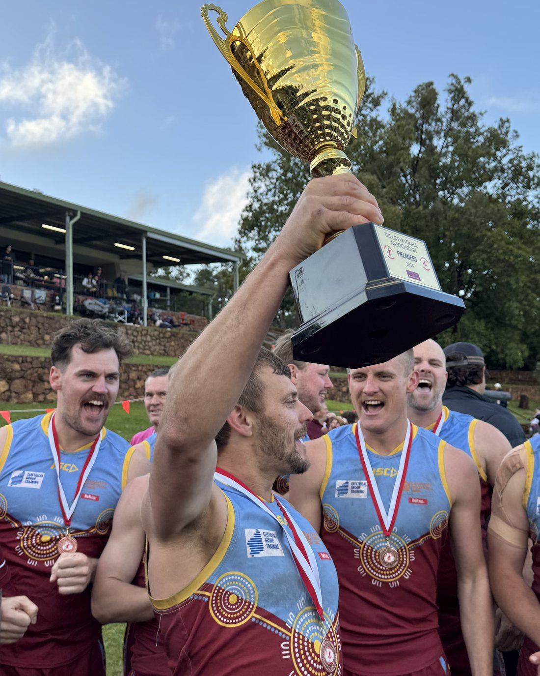 A Swan View player holding the premiership cup high