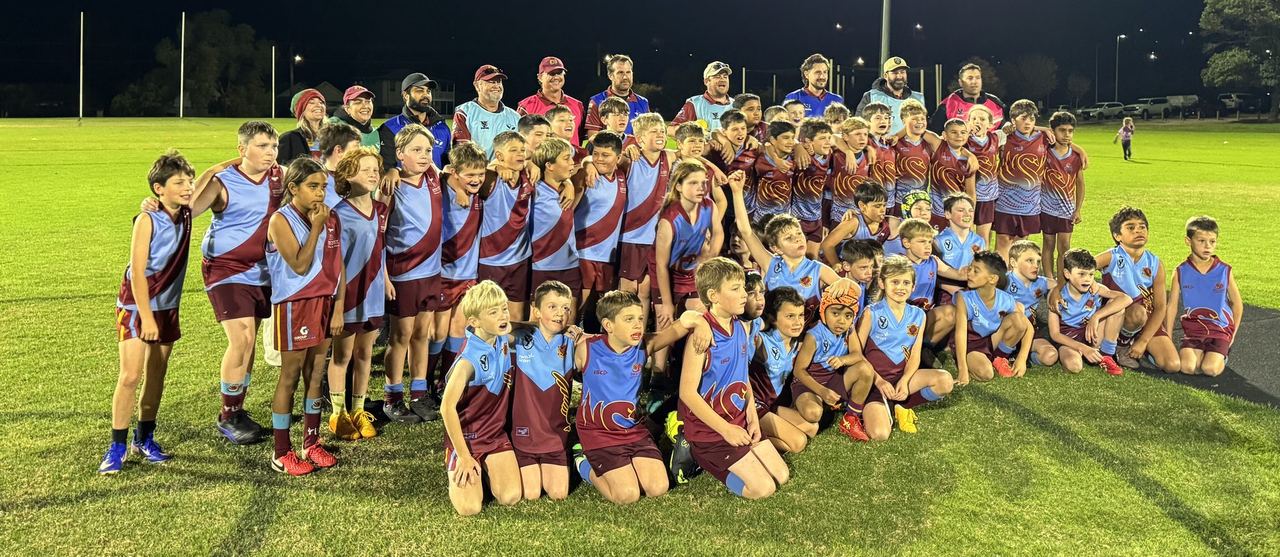Junior players gathered on the oval at night under the lights
